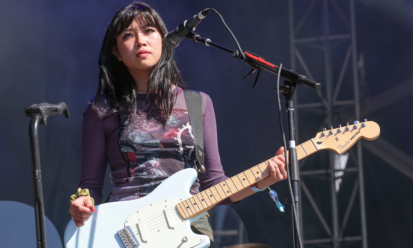beabadoobee performing with a white electric guitar on stage